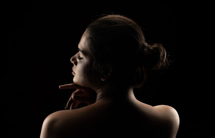 girl standing back with black background