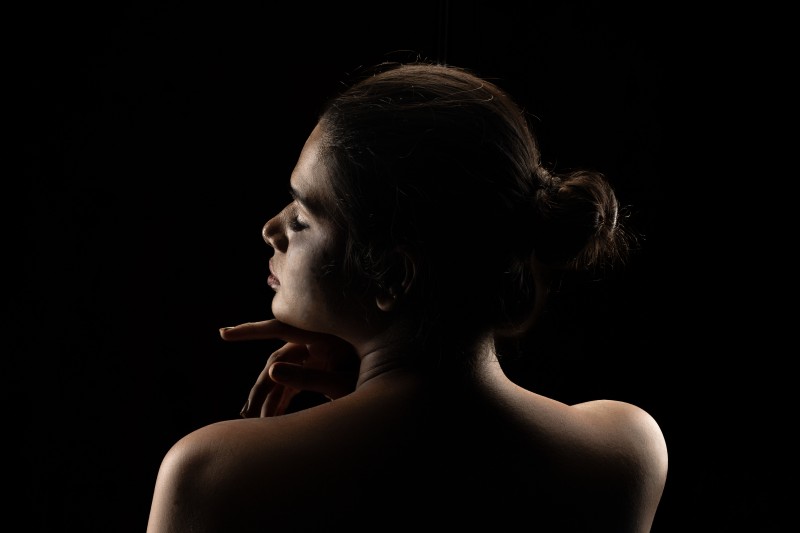 girl standing back with black background