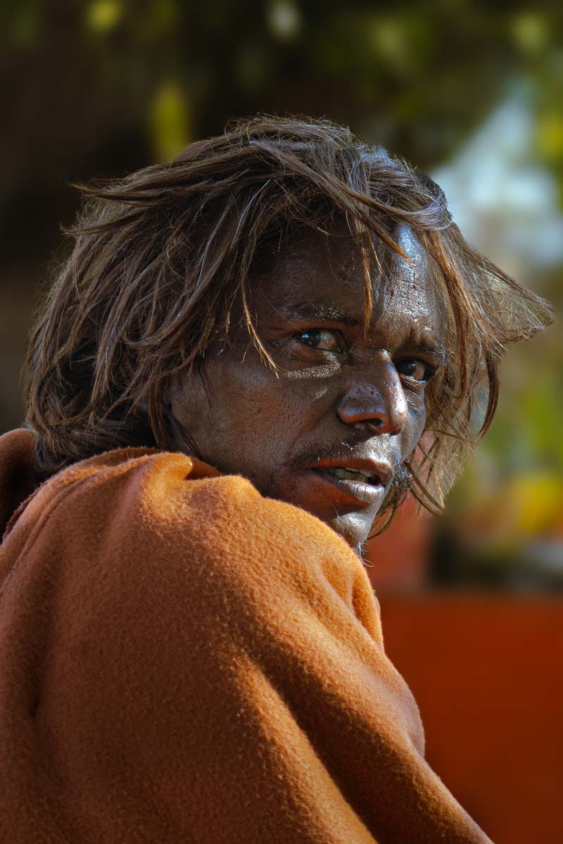 a man with long hairs and orange cloth