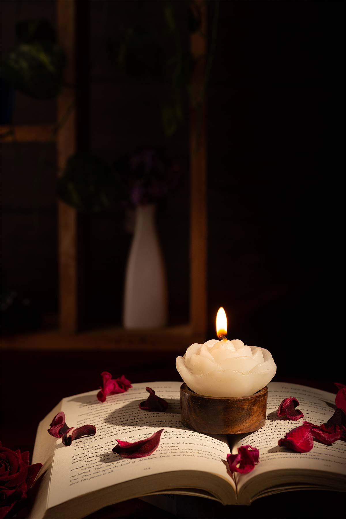 Burning rose shaped candles on top of the book