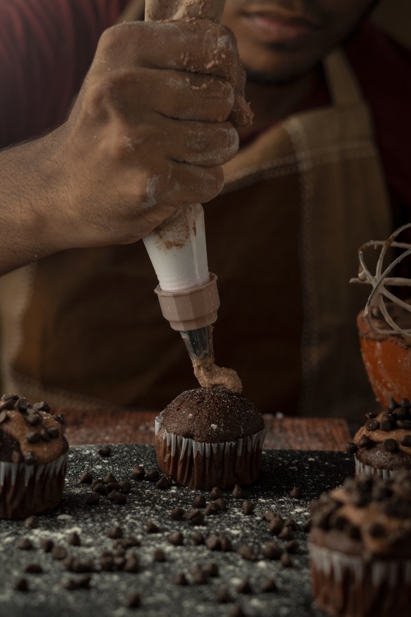 topping chocolate on the cup cake and clay vessel near it