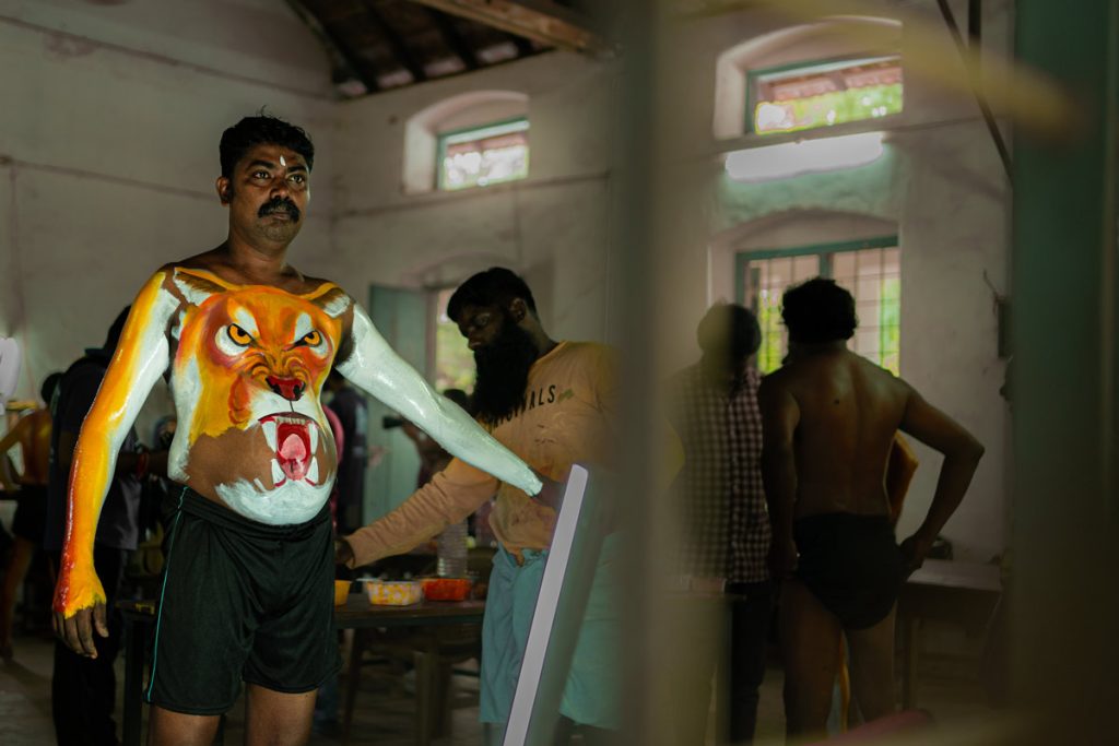 A photo of pulikali artist painting in progress.