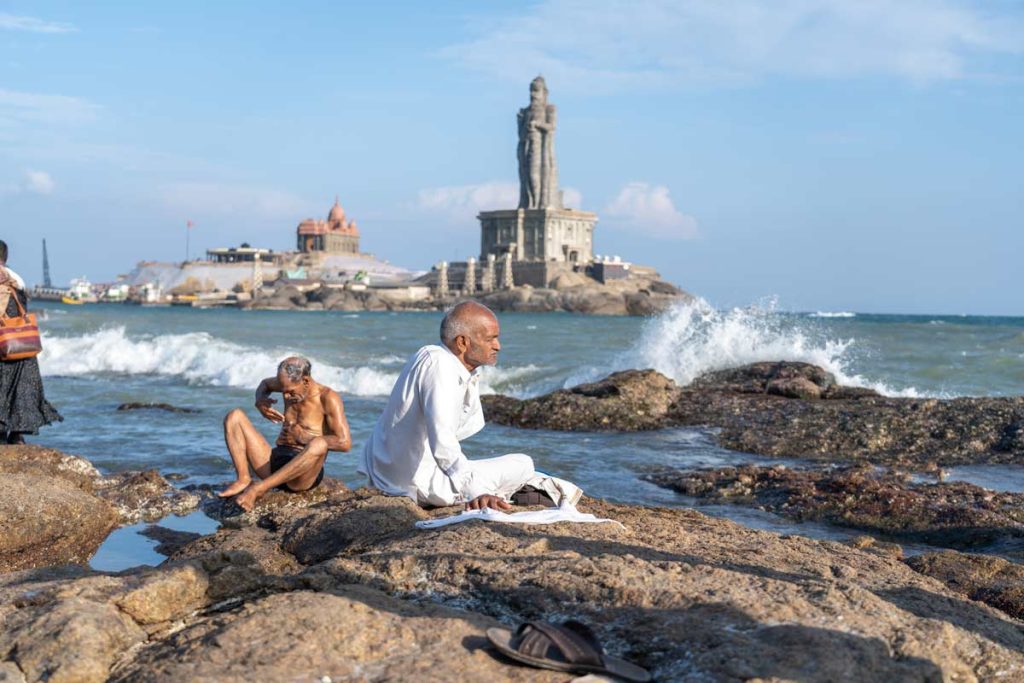 old man sitting in front of Thiruvalluvar Statue