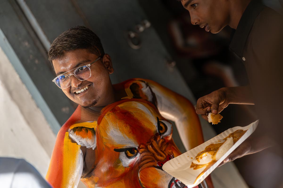 feastinghues painted tiger is eating food in between pulikali makeup part