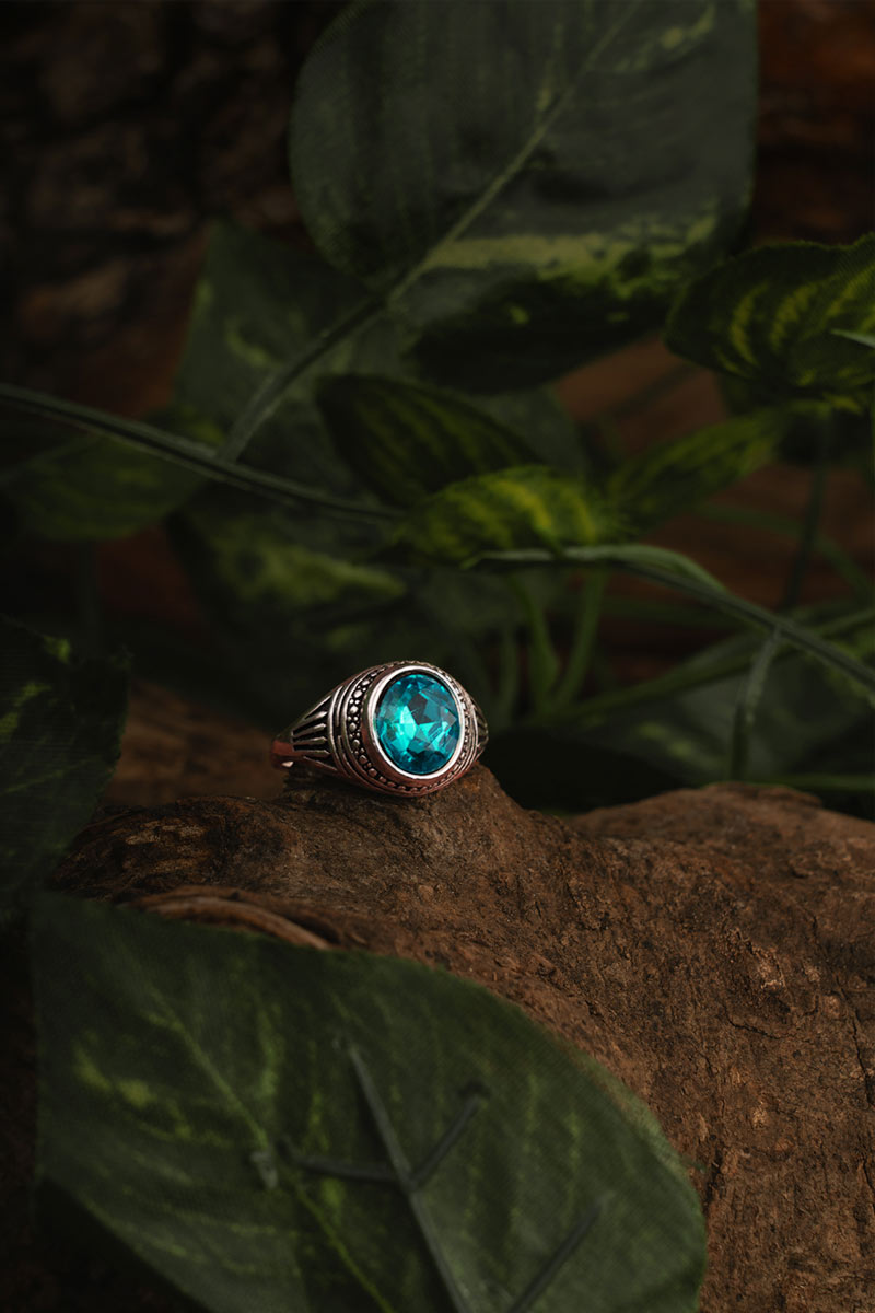 blue crystal ring placed on a wooden branch