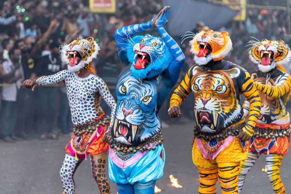 blue painted tiger pose in between dancing