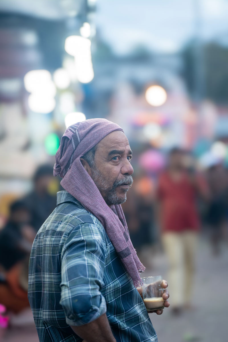 A guy drinking tea on the street.