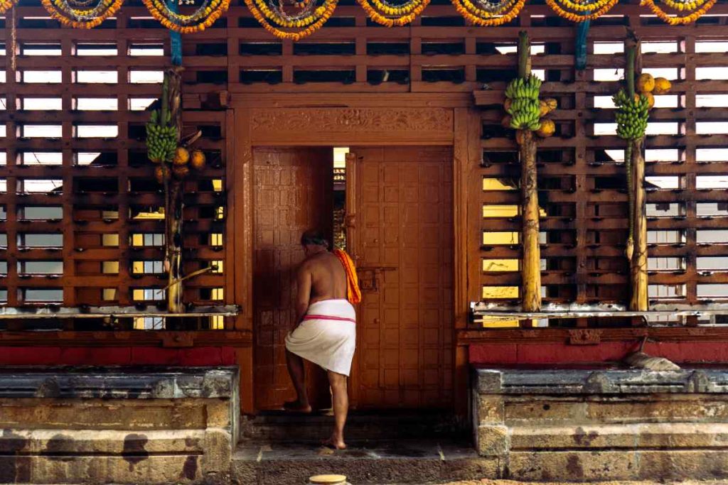 Devotee opening temple door.