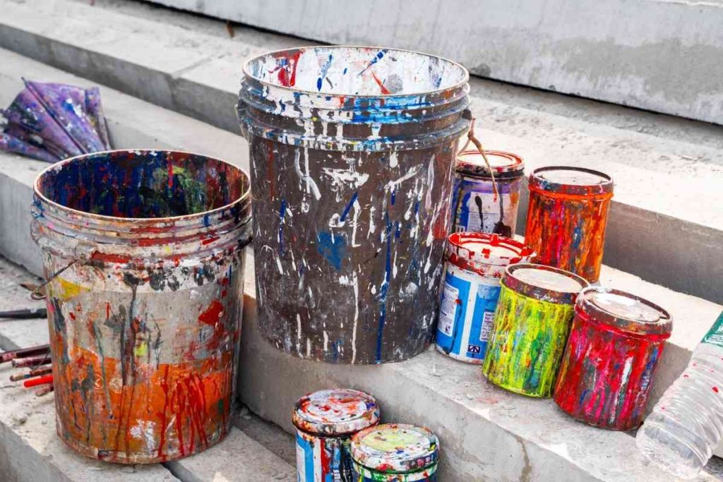 Paint buckets with splashes of color on steps.