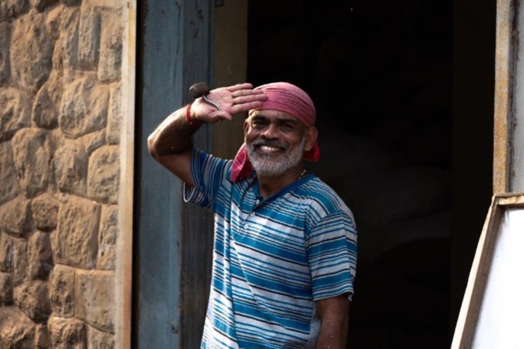 Silent Satisfaction Smiling worker in a red headscarf saluting.