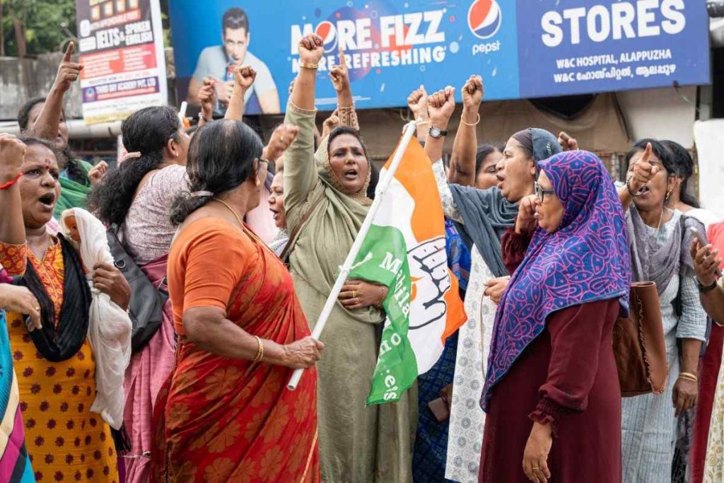 Voices of resistance women protestors march with raised fists, chanting slogans and holding a political flag.