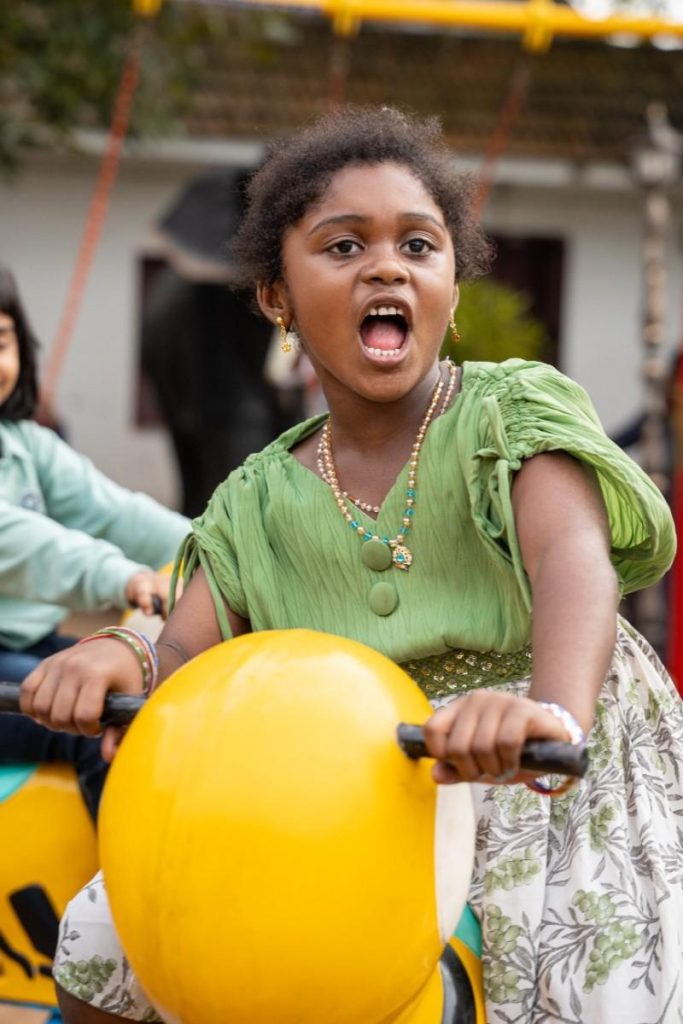 Joy – A girl in a green dress enjoying a ride.