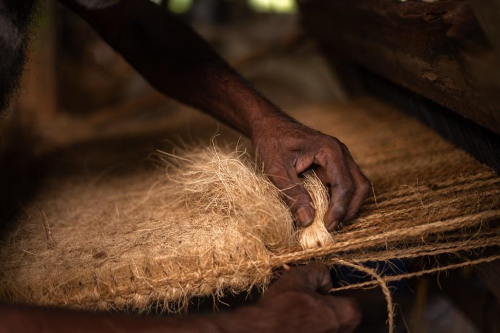 Handcrafted Strength Hands weaving coconut fiber into ropes.