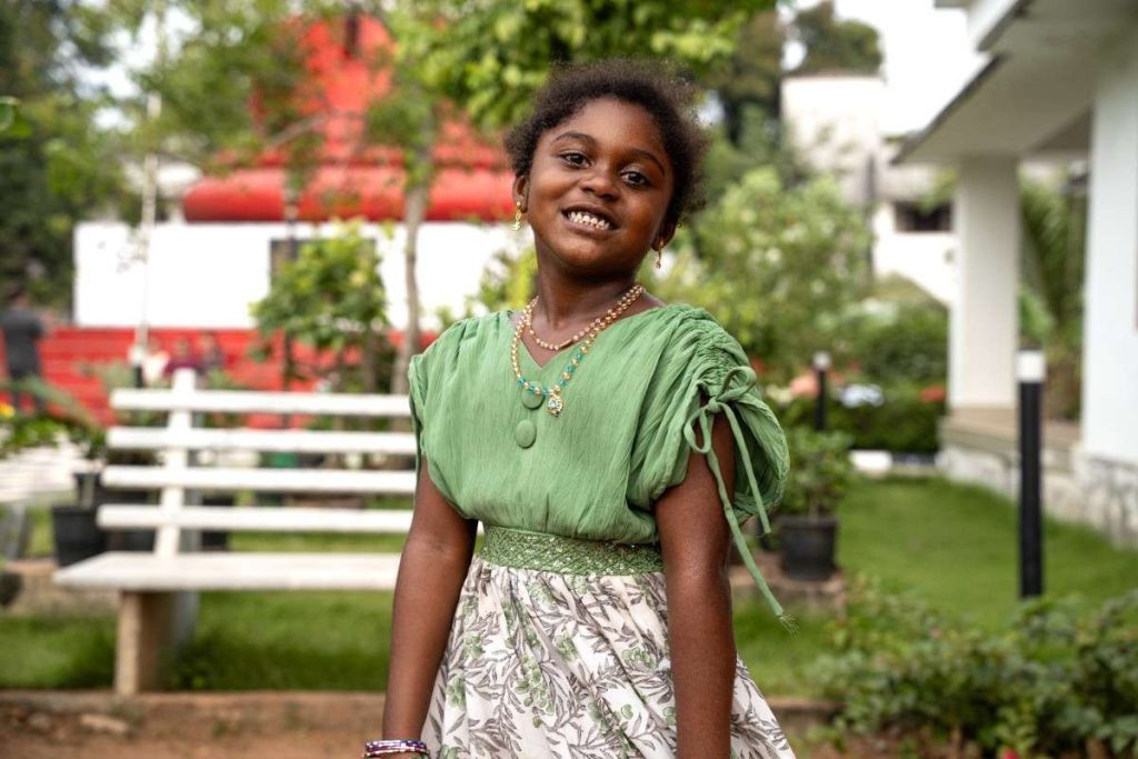 Brief Smile A girl in a green dress smiles.