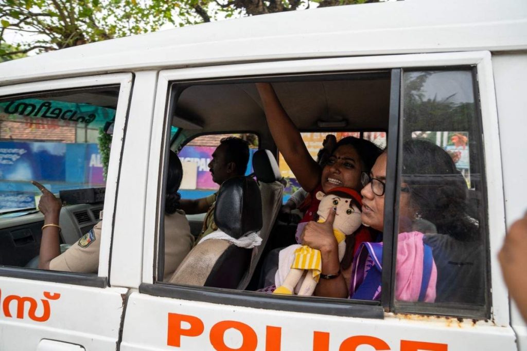 Defiant arrest a protester raises her hand defiantly inside a police vehicle.