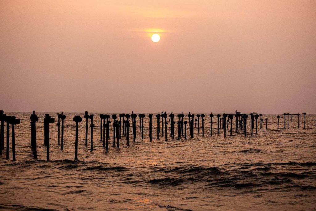 Sunset Passage Old pier ruins silhouetted against a golden sunset.