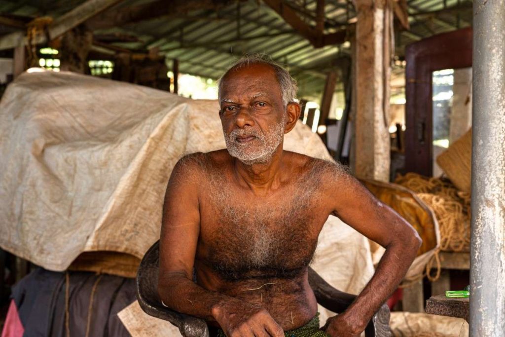 Master Weaver Elderly man with a thoughtful expression in a coir workshop.