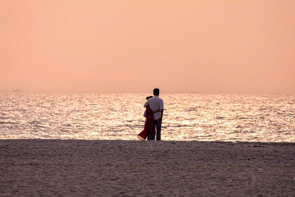 Love A couple embraces at sunset by the sea.