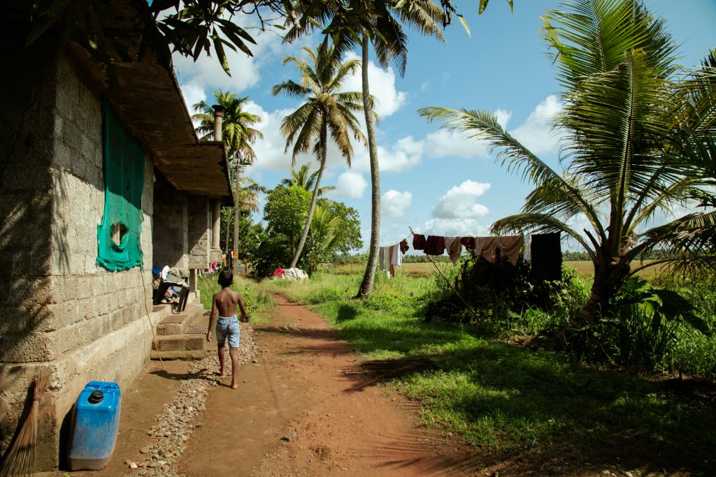 A barefoot child walks along a blissful rural path.