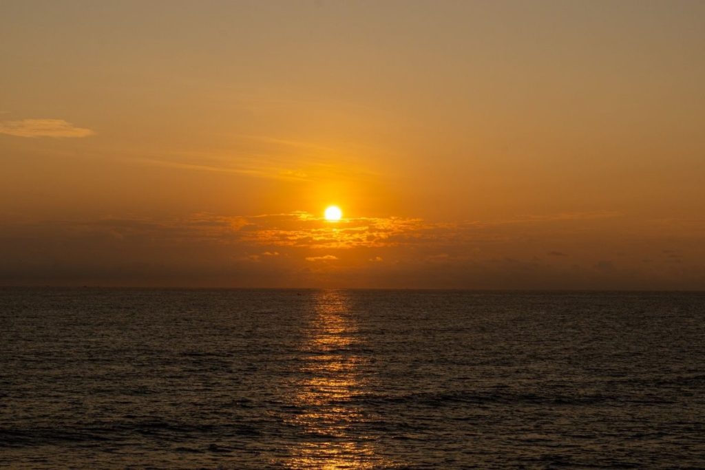 the golden sun peeking above the seascape