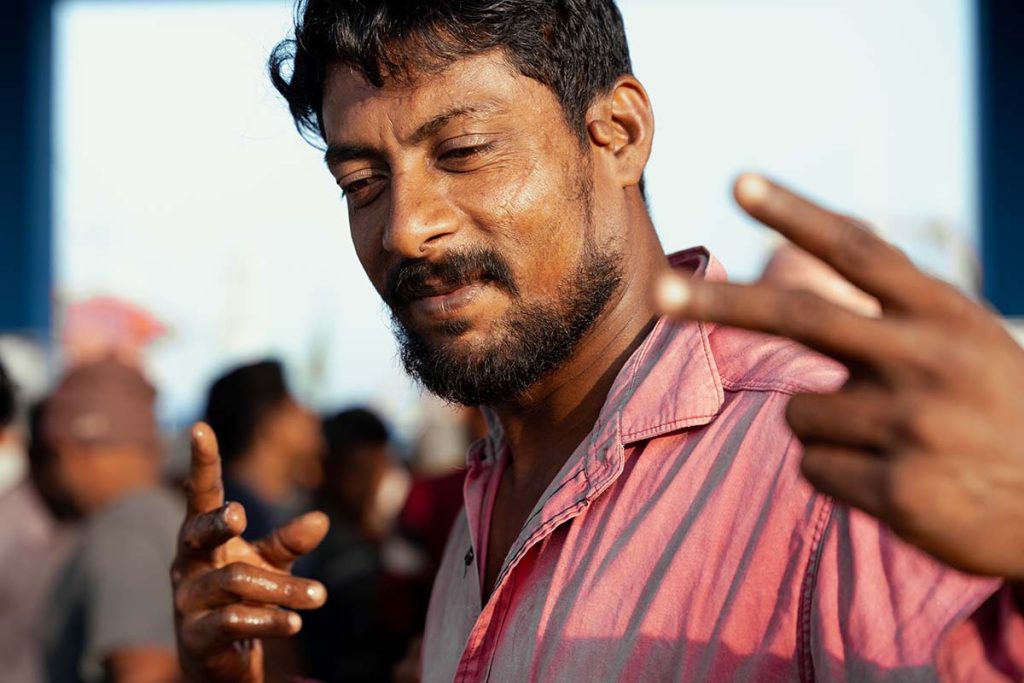 A worker showing victory in the middle of his work.