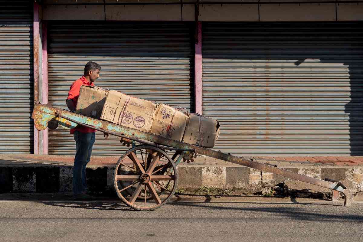 Wheels of labor roll as a porter moves goods.