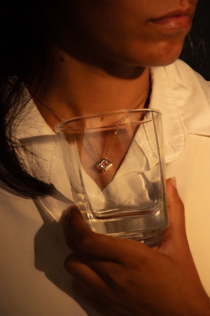 A crystal clear pendant framed inside glass.