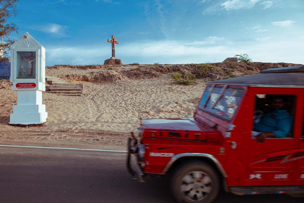 faith and motion, a red jeep near the sacred cross.