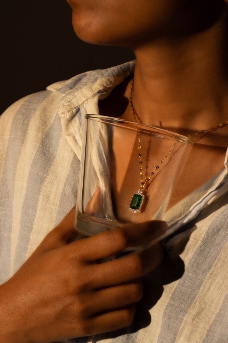 A gleaming green stone pendant framed inside glass.