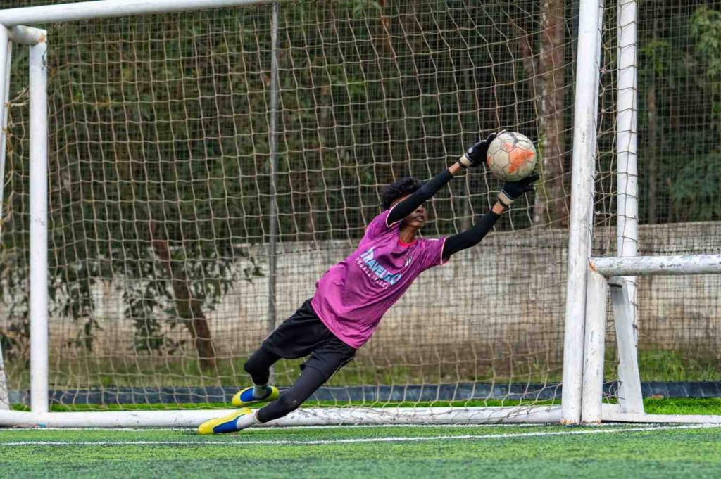 Mastering the dive, a keeper dominates the net.