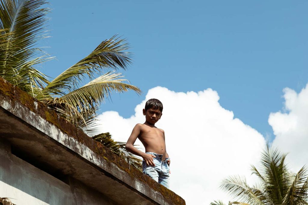 
Rooftop Stance A boy stands on a rooftop under a blue sky