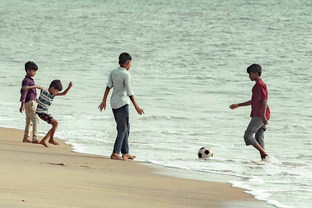 The sand strikers enjoy playing football on the beach.