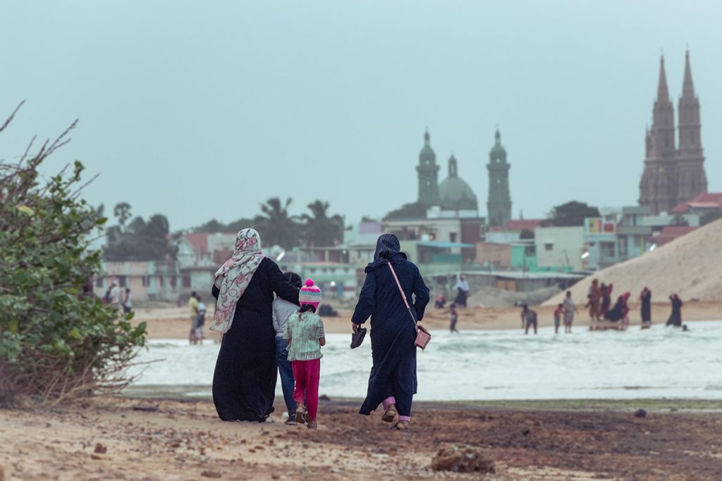 shared journey .Women and children walking along shore.