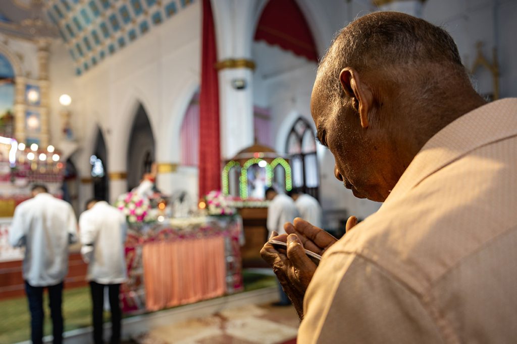 Silent Devotion A devotee silently praying during a church service in Kerala.