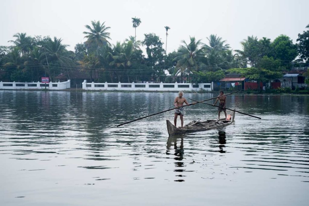 Two village men silent glide collecting clay from backwaters.