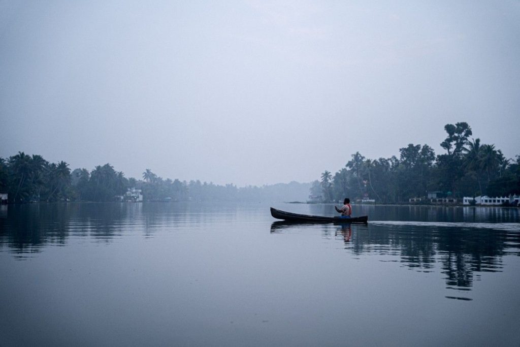 Silent journey paddling on calm misty water.