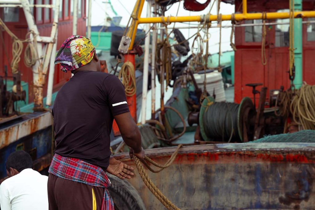 Fisherman with steady hands pulls the docking rope tight.