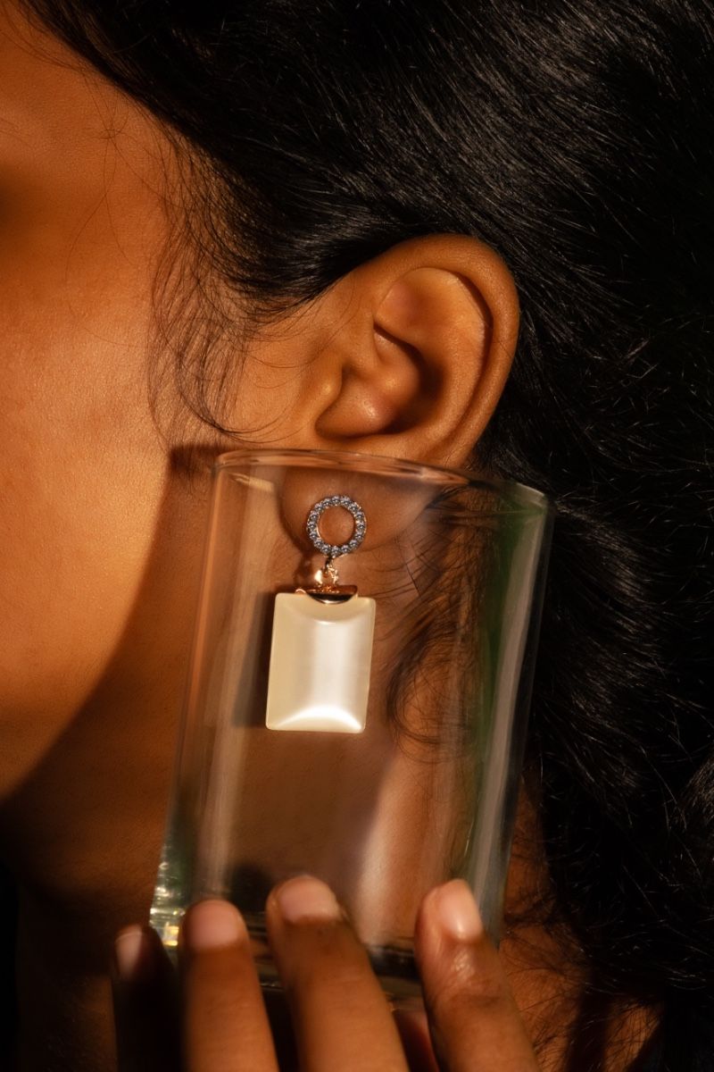 stoned beauty of an earring with white big stone framed inside glass.