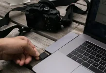 Best Photo-Sharing Practices for Wedding and Event Photographers photographer inserting memory card into laptop to upload wedding photos