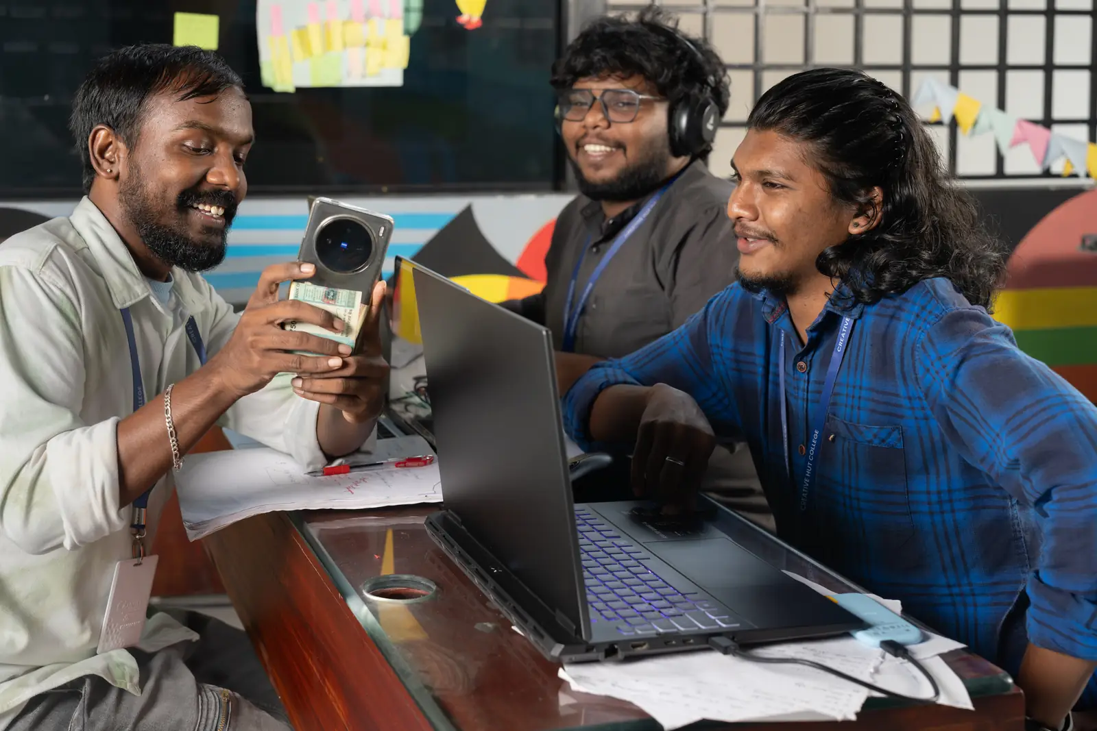 AI content creation career: student filming on a phone while classmates work on a laptop