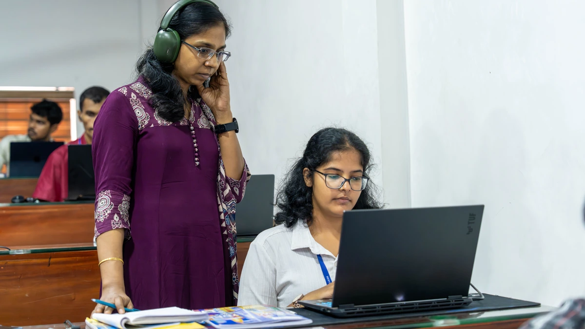 Student with headphones working at a laptop in an AI filmmaking diploma class
