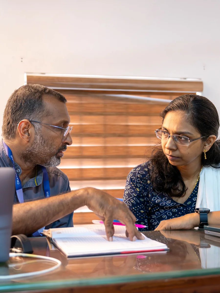 Film mentor reviewing a notebook with a student at Creative Hut Academy