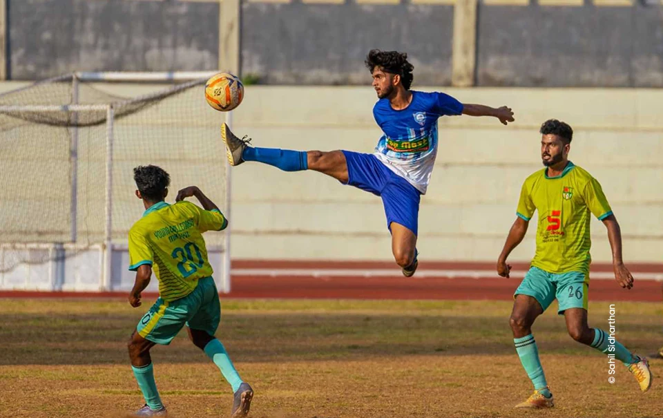 Footballer in blue leaping to kick a high ball, sports photography course at Creative Hut Academy