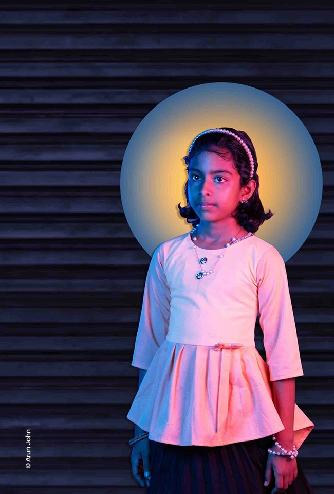 Girl in pink standing in front of a glowing halo, advertising photograph by Arun John, Creative Hut Academy