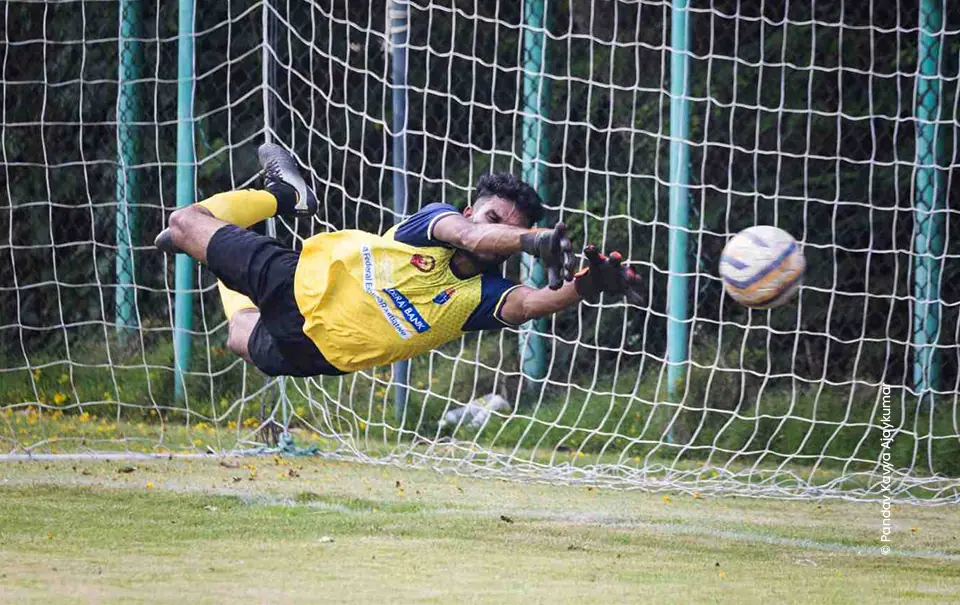 Goalkeeper in yellow diving full stretch for the ball, sports photography course at Creative Hut Academy