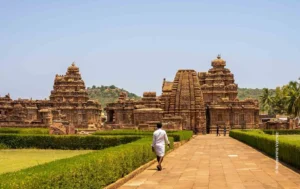 Man walking toward Pattadakal temples along a stone path, architecture photograph by Narasimha Varma, Creative Hut Academy