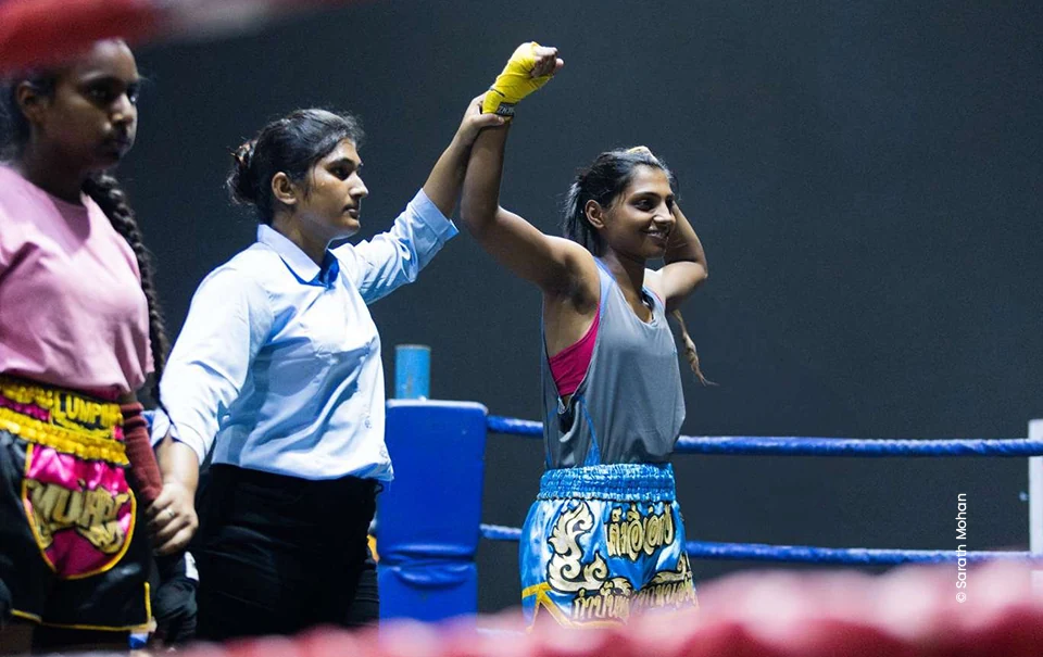 Referee raising a woman fighter's hand after a bout, sports photograph by Sarath Mohan, Creative Hut Academy