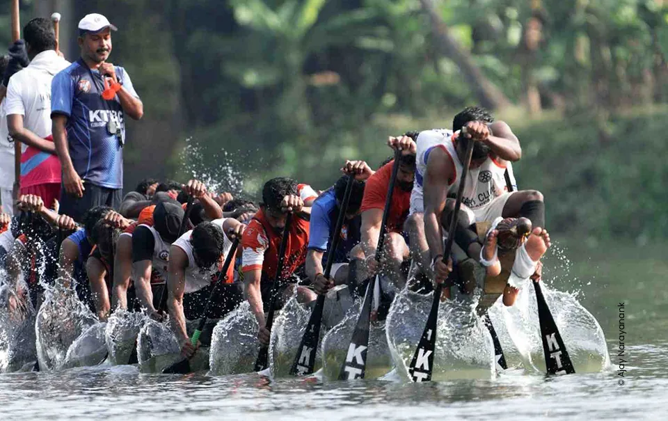 Rowers paddling in unison as water sprays during a boat race, sports photograph by Ajay Narayanan K, Creative Hut Academy