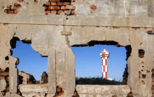 Ruined wall with a lighthouse framed through a breach, architecture photograph by Heet Dave, Creative Hut Academy