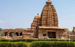 Sandstone temple tower behind green hedges, architecture photograph by Narasimha Varma, Creative Hut Academy